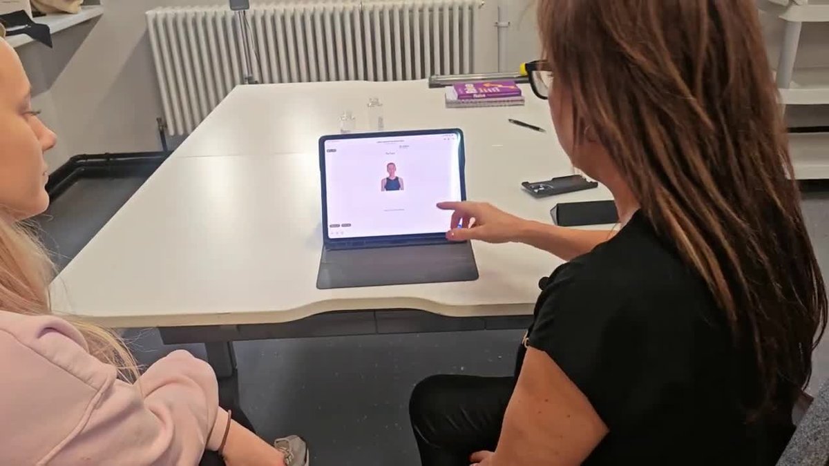 Louise talking a learner through the uGlow application routine on a tablet